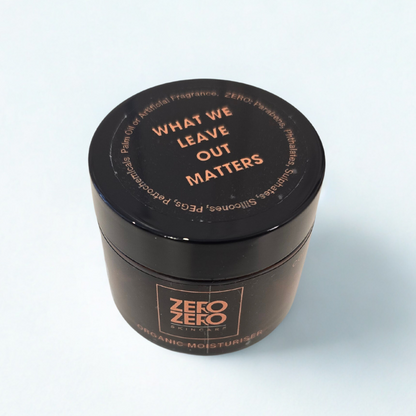 Cosmetics jar with black lid and amber glass jar on a light gray background. On the lid is written in orange "What we leave out matters"