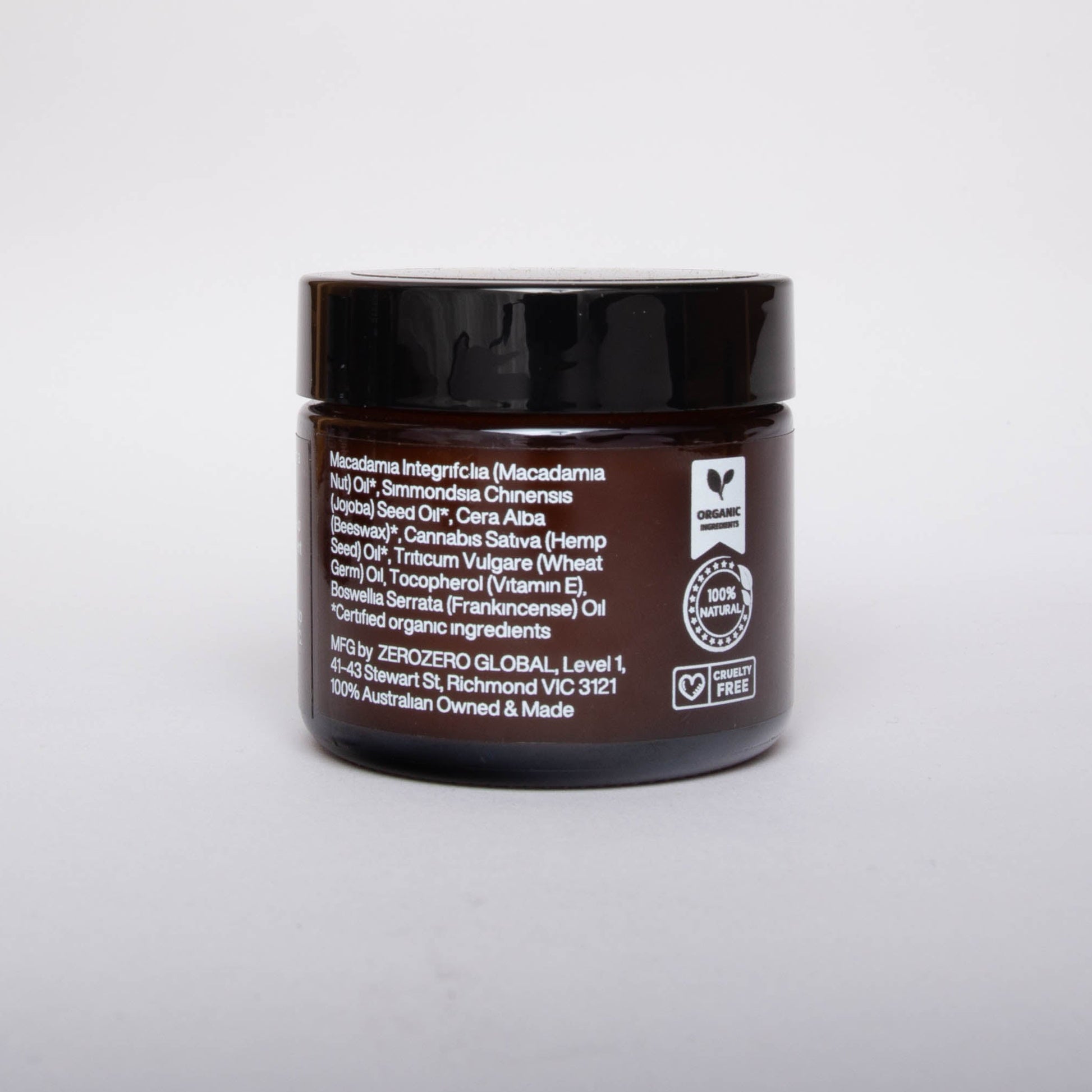 Amber glass cosmetics jar with black lid and white writing with ingredients and the product certifications. 